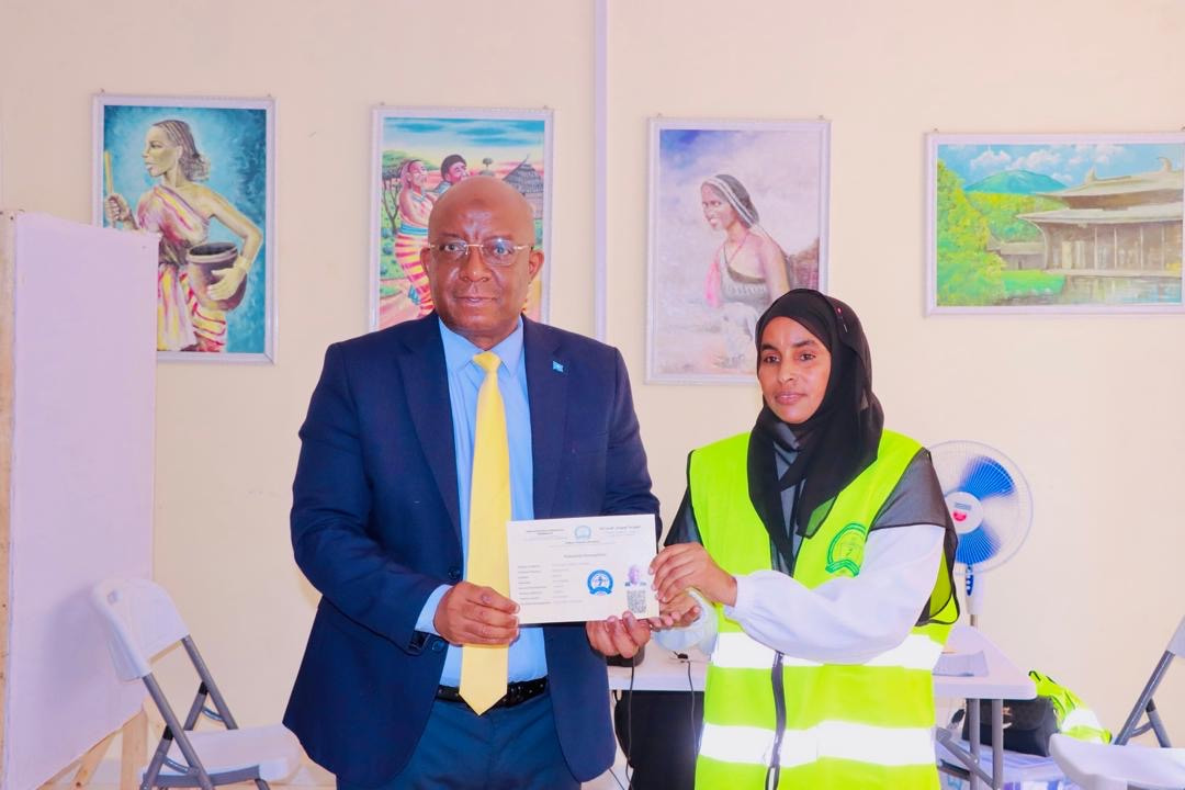 Minister of Information gets his voter registration card